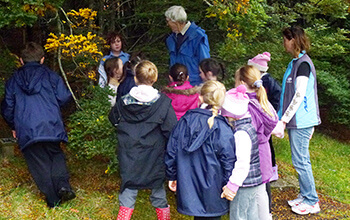 A volunteer educator with a group of interested school children at The Tasmanian Arboretum