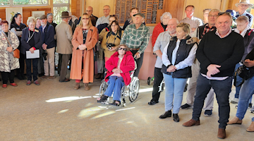 A group of members standing in the Education Centre listening to a presentation.